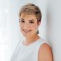 Woman with short hair smiles at camera.