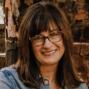 Woman with bangs and glasses smiling