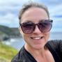 Woman with her dark hair pulled back wearing sunglasses