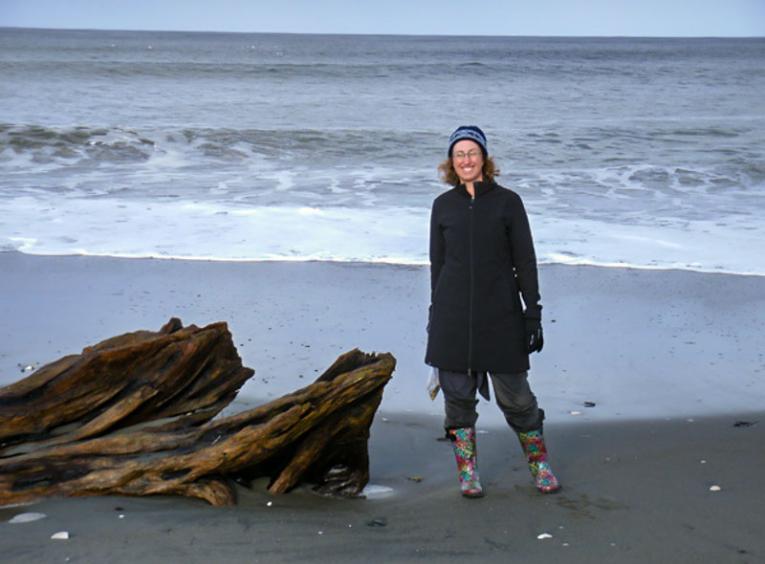 Andrea standing on the shore of a beach at the ocean.