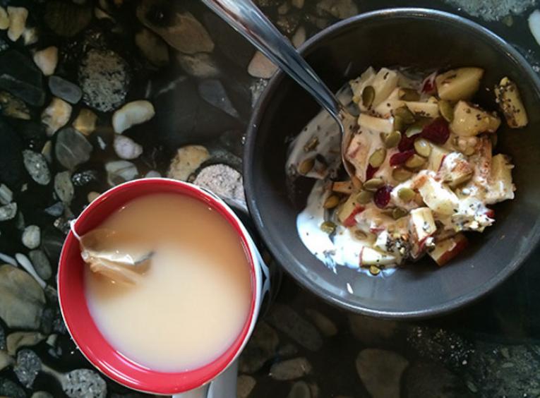 Bowl of yogurt with cup of tea.