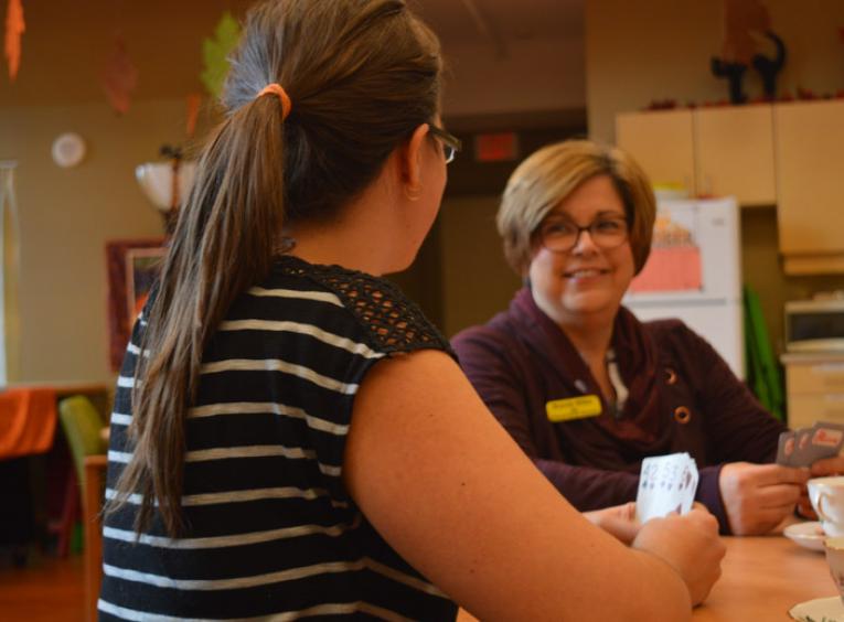 Two female staff members play cards.