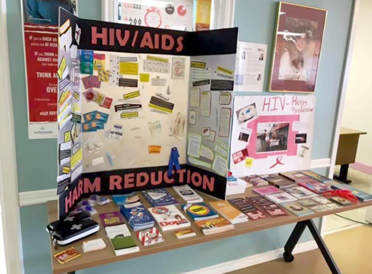 A table of HIV Awareness materials is pictured.