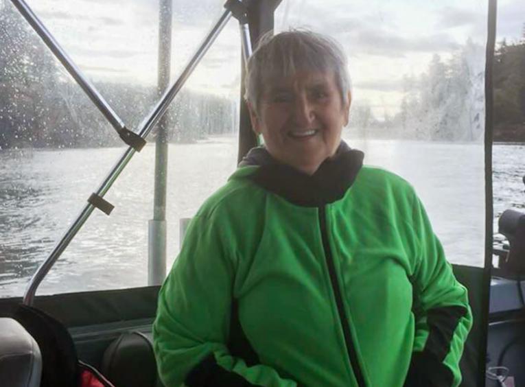 Elder Semiguul sits on a boat, smiling at the camera.