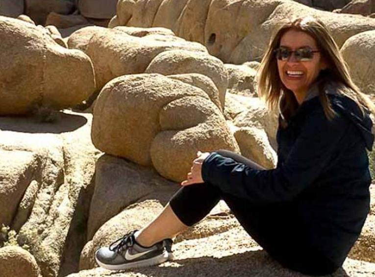 Patti sitting on a boulder amongst rocks.