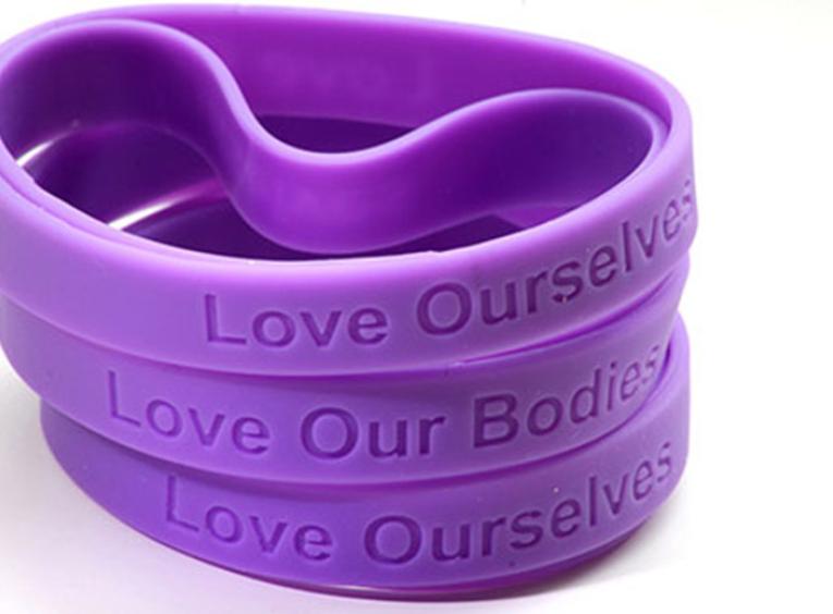 Wristbands stating Love Ourselves and Love Our Bodies.