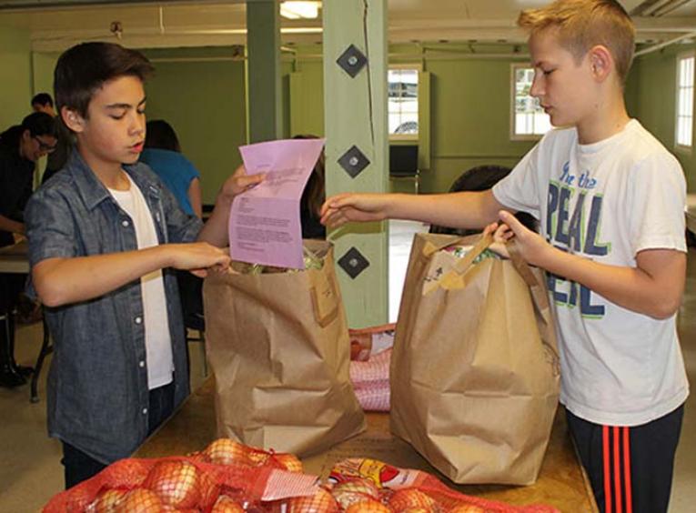 Two young boys sorting produce.