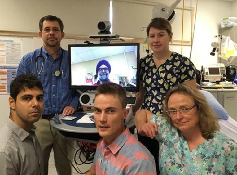 Health care providers posing with a telehealth system.