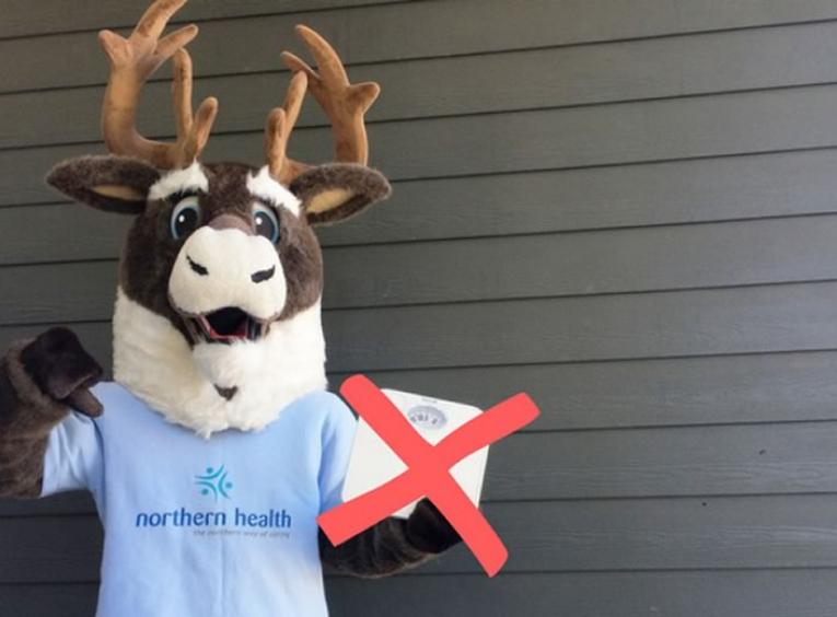 Spirit the caribou mascot holding scale