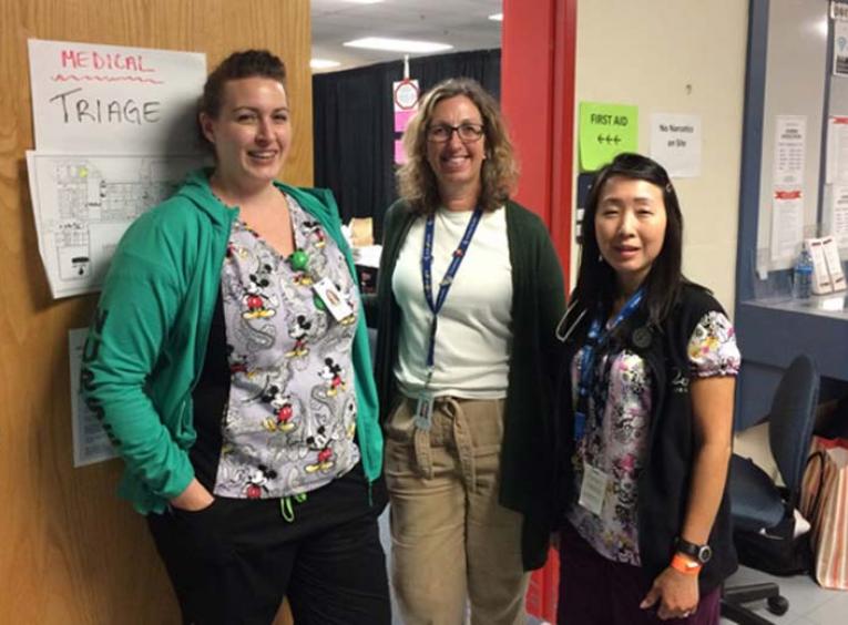 Three women standing posing in doorway.