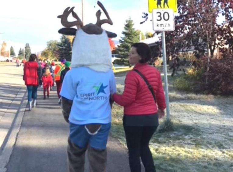 NH Mascot, Spirit the Caribou, walking to school with woman wearing read puffer jacket..