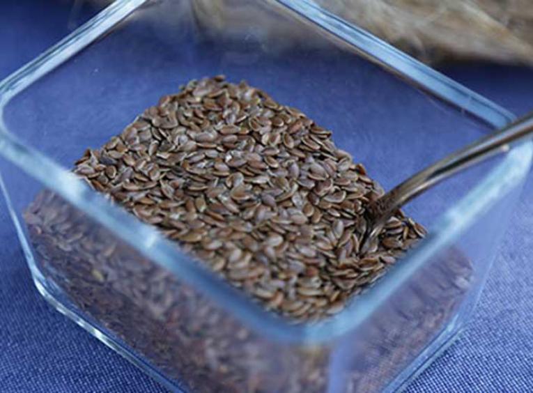 Flax seeds in a glass container dish.