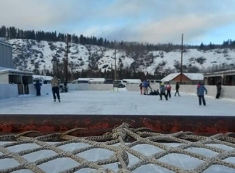 People skating on an outdoor ice rink.