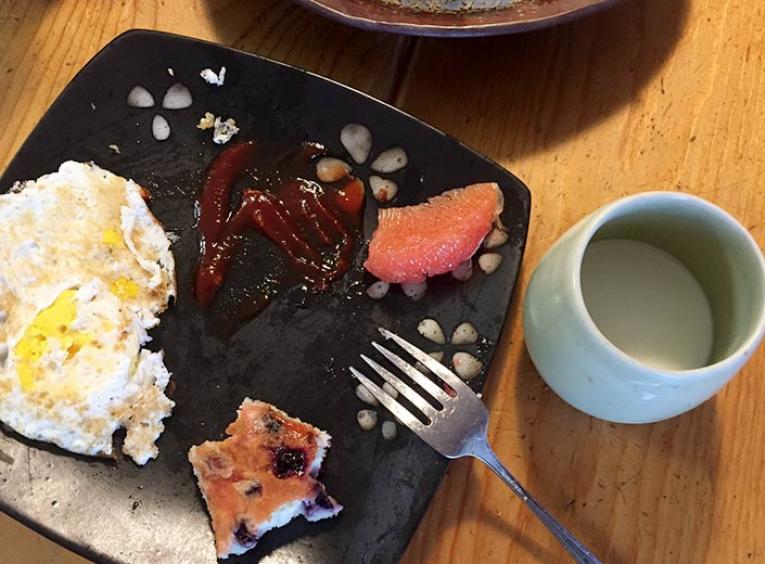 A half-eaten breakfast sits on a plate.