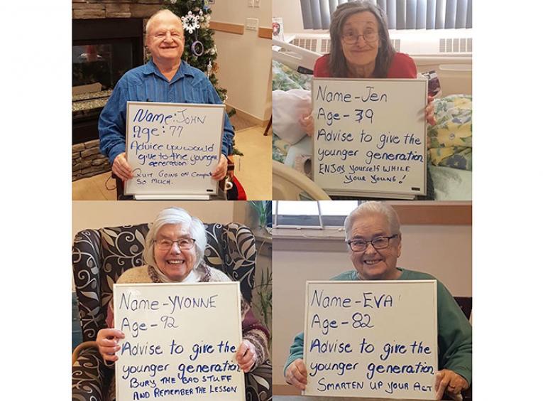Four seniors hold white boards with messages of advice for youth