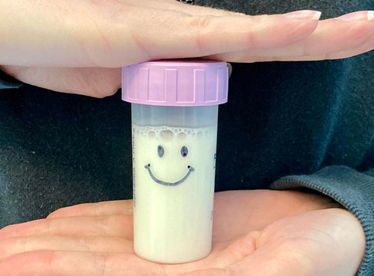 Small vial of human milk with a smiley face