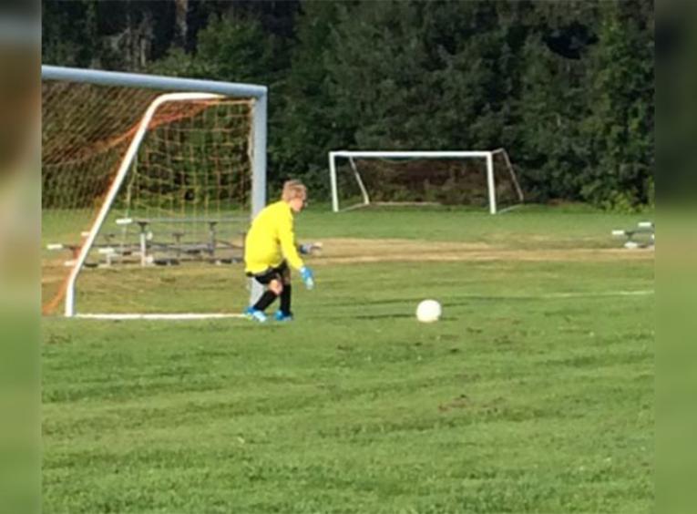 Boy in yellow jersey playing soccer