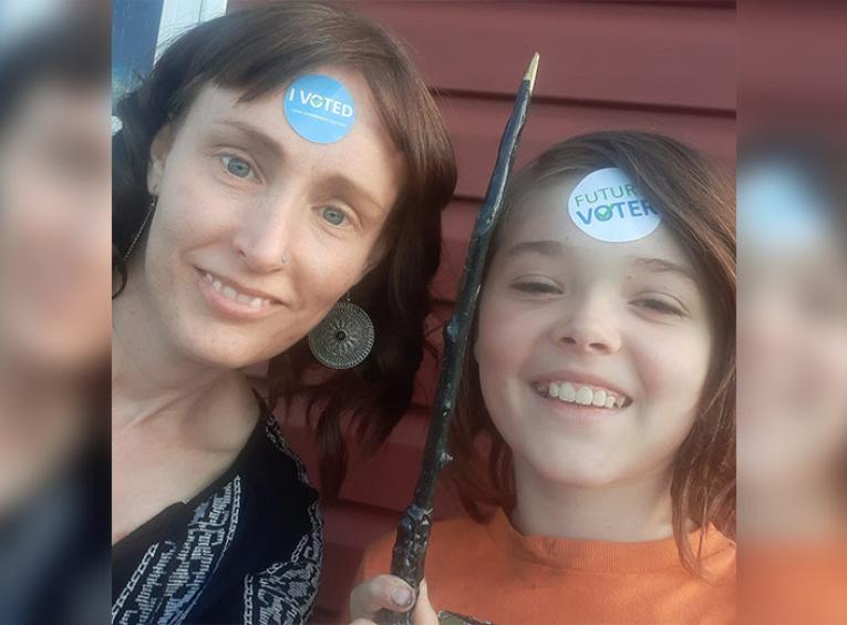 Woman and her son with voter stickers on their foreheads.