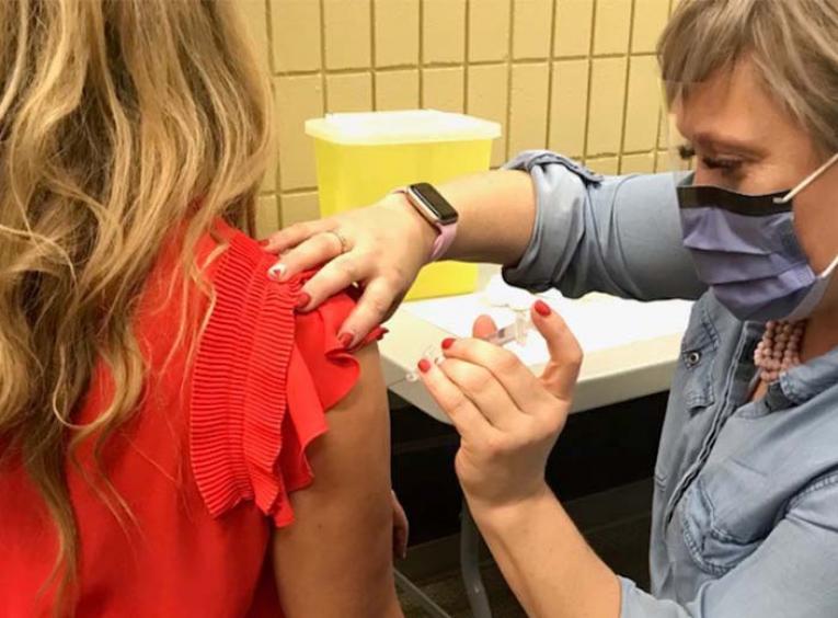 Nurse wearing mask gives injection