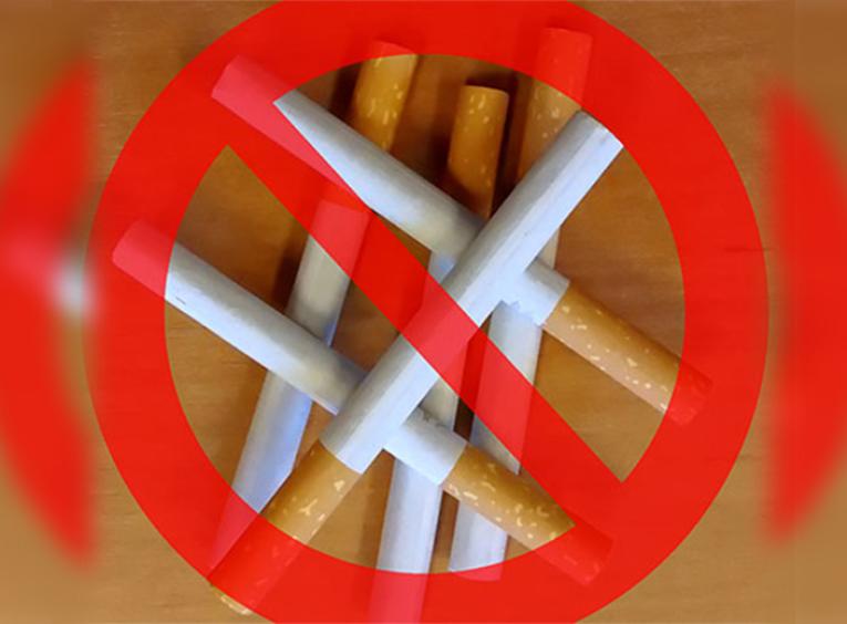 Pile of cigarettes with red ban crossing over top