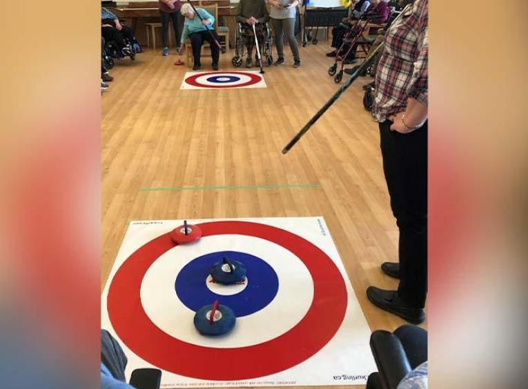 Seniors play indoor curling game