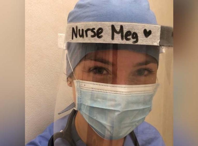 a nurse wearing a face shield and mask. On top of her shield is says "nurse meg"