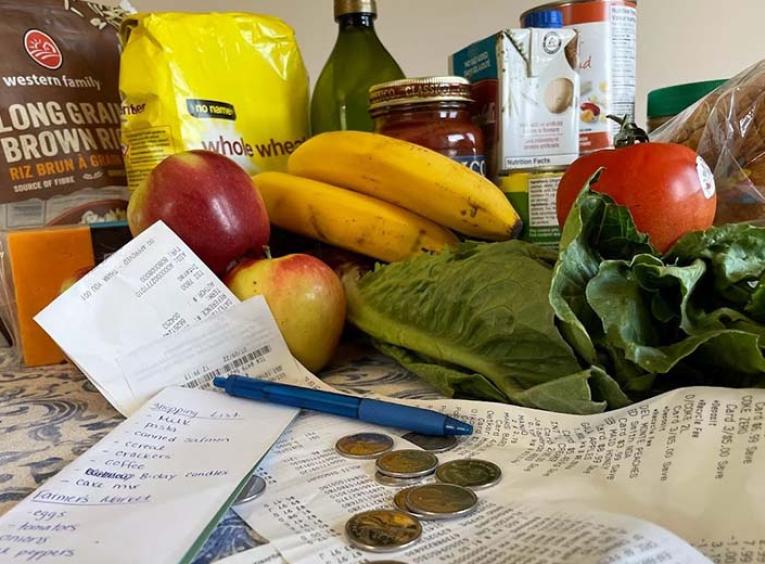 an array of groceries sits on a counter with some change in front 