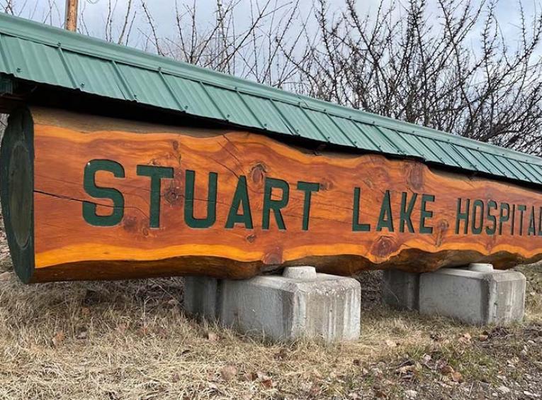 A carved wooden sign that says Stuart Lake Hospital