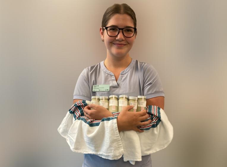 Nurse holds bottles of donated milk