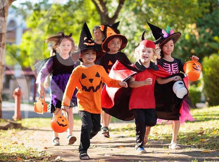 Kids running in costume to collect candy. 