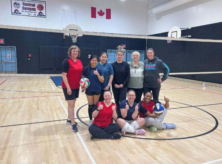 Athletes pose in the middle of a school gym