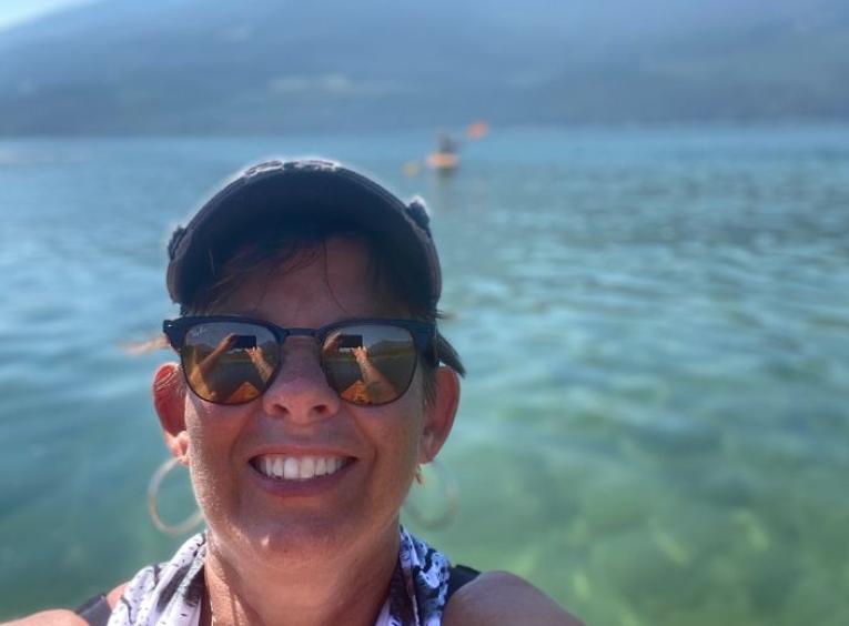 Viva standing in front of  a blue lake
