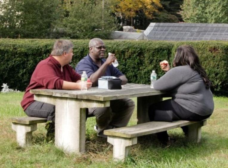 Adults in larger bodies enjoying accessible seating at a picnic table