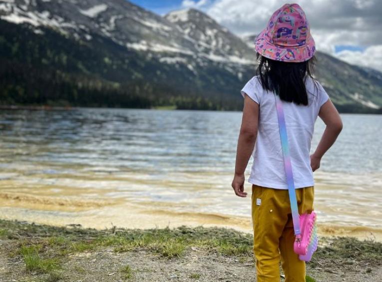 A child looks out over a lake