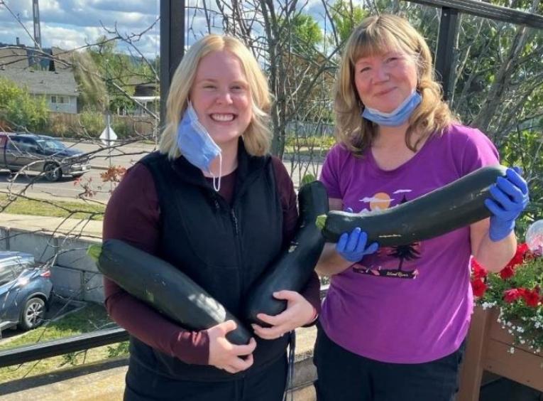 NH staff holding zucchinis