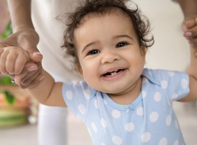 A toddler smiles with 2 new teeth