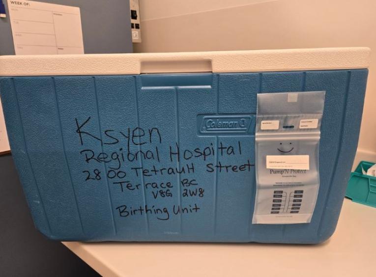 A blue cooler containing human milk donations in transport