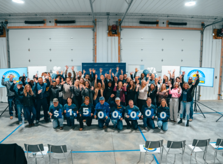Group of people stand behind sign that reads 1.5 million dollars