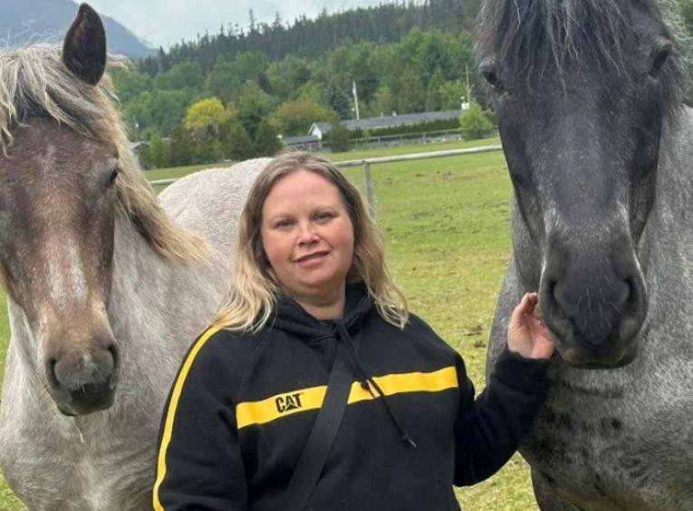 Nicole standing with 2 horses