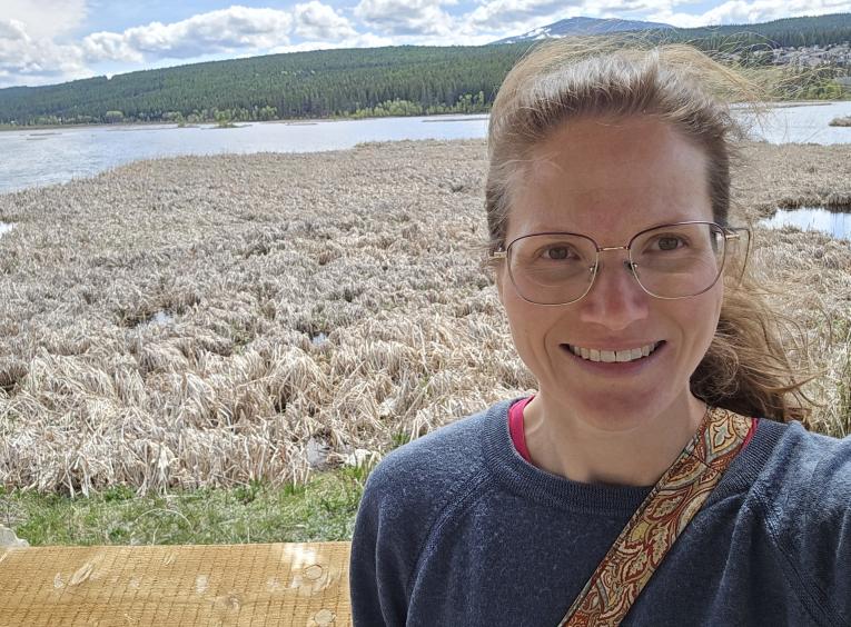 Courtenay standing at a lake
