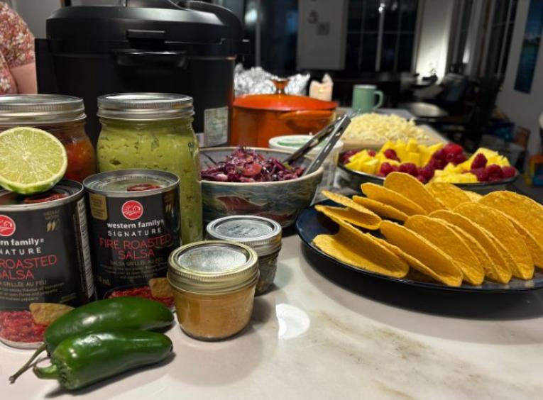 Ingredients for a taco buffet are laid out on a kitchen counter.