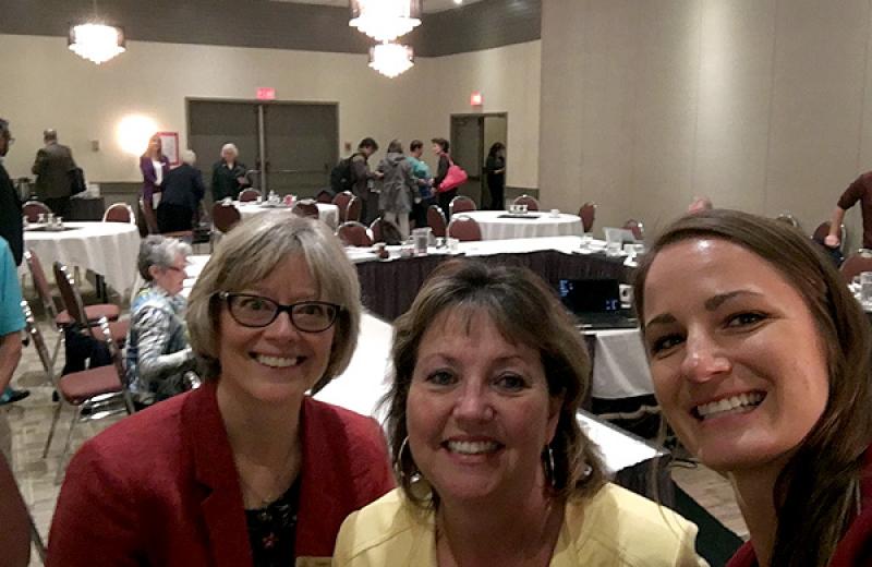 From left to right, Cathy Ulrich, NH CEO; Colleen Nyce, NH Board Chair; and Julianne Kucheran, Community Consultant, Urban Matters smile into the camera as a meeting breaks behind them.