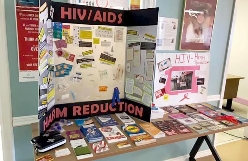 A table of HIV Awareness materials is pictured.