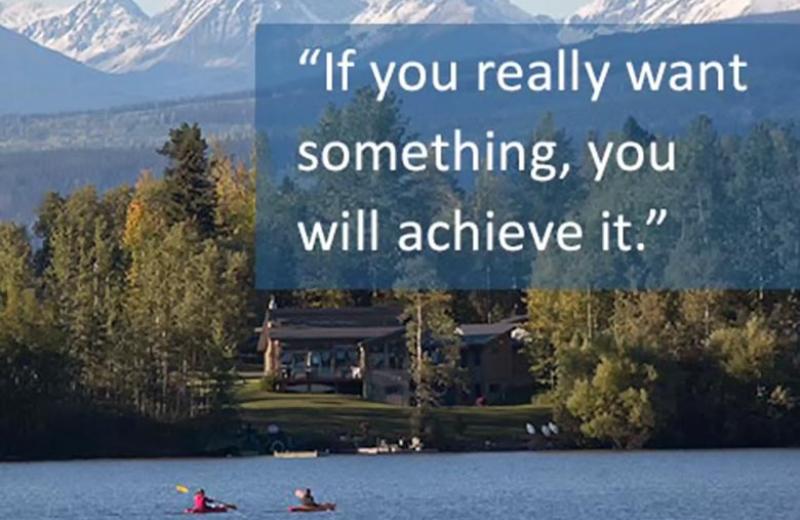 People kayaking on lake with resort and mountains behind with "If you really want something, you will achieve it" quote on the graphic