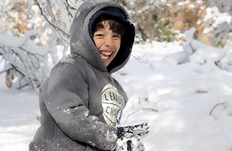 Boy playing in snow with a hoodie on
