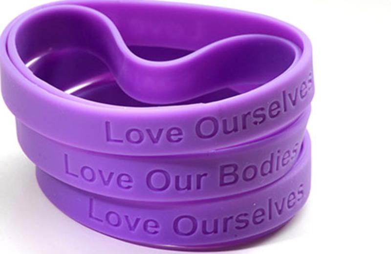 Wristbands stating Love Ourselves and Love Our Bodies.