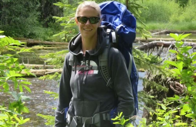 Woman with backpack hiking in the forest.