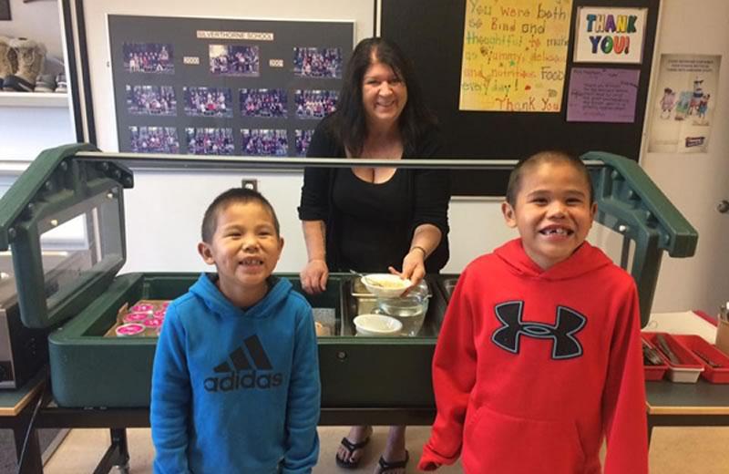 Evelyn Meehan with two students and the school's salad bar.