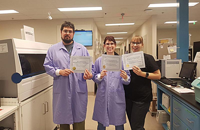 The lab technologist team standing with the certificate awards.