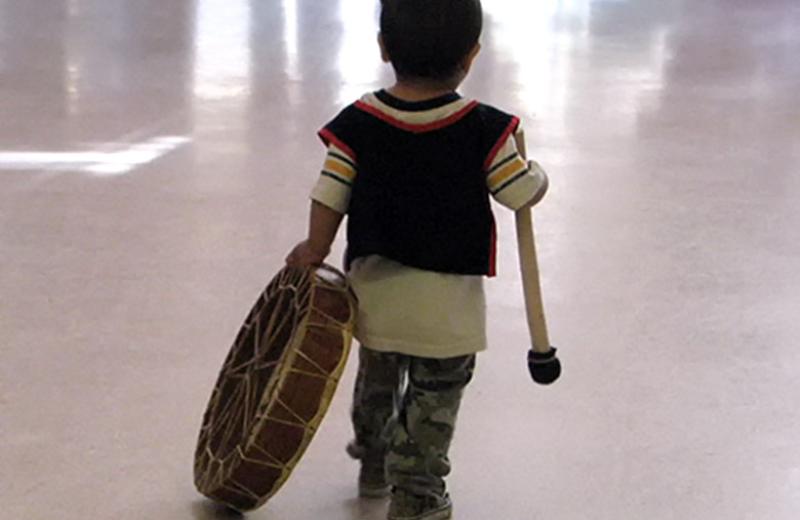 Young boy carrying drum